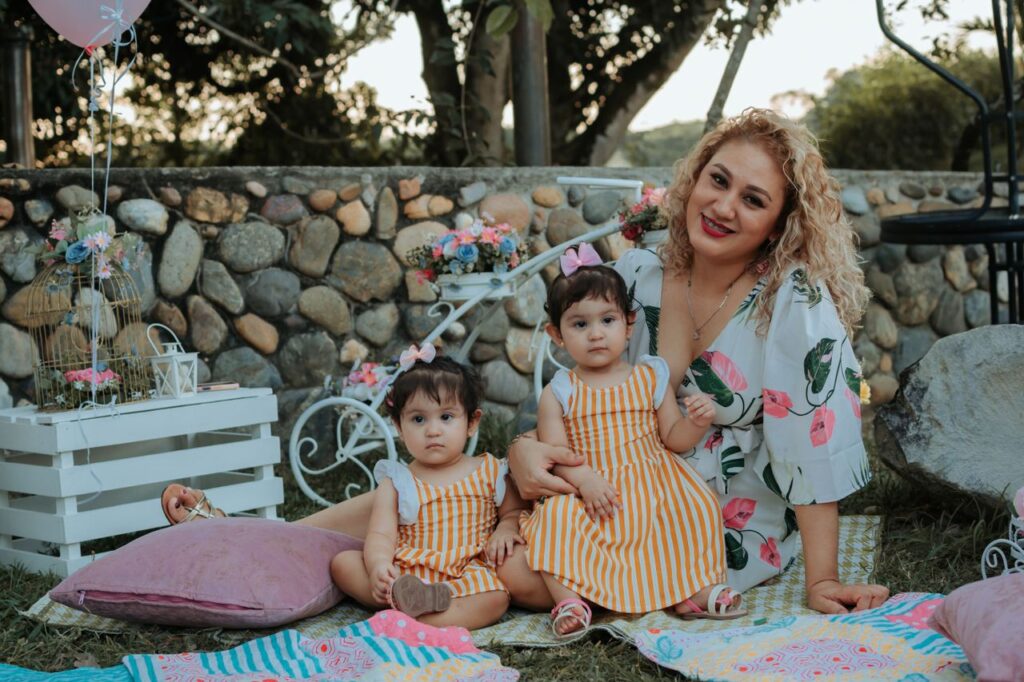 A joyful family picnic in La Dorada, Colombia featuring a mother and her two children outdoors.